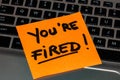 Writing on colorful sticky note You are fired. Text with You are fired on paper. Sticky note, post it on keyboard Royalty Free Stock Photo