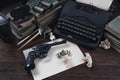 Writing a crime fiction story - old retro vintage typewriter and revolver gun with ammunitions, books, blank paper, old ink pen Royalty Free Stock Photo