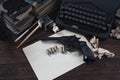 Writing a crime fiction story - old retro vintage typewriter and revolver gun with ammunitions, books, blank paper, old ink pen Royalty Free Stock Photo