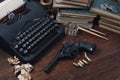 Writing a crime fiction story - old retro vintage typewriter and revolver gun with ammunitions, books, papers, old ink pen Royalty Free Stock Photo