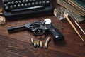 Writing a crime fiction story - old retro vintage typewriter and revolver gun with ammunitions, books, papers, old ink pen Royalty Free Stock Photo