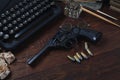 Writing a crime fiction story - old retro vintage typewriter and revolver gun with ammunitions, books, papers, old ink pen Royalty Free Stock Photo