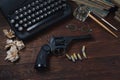 Writing a crime fiction story - old retro vintage typewriter and revolver gun with ammunitions, books, papers, old ink pen Royalty Free Stock Photo