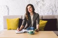 Writing dairy on notebook in coffee shop, concept as memory of life. woman with mobile phone and pen on Wooden table Royalty Free Stock Photo