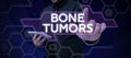 Hand writing sign Bone Tumors. Concept meaning can be either benign or malignant growths found in the bone