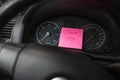 Writing drive safely on memo post reminder. Text on sticky paper inside car dashboard