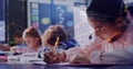 Writing girl pink-shirted leaning over notebook in class, using yellow pencil with code overlay Royalty Free Stock Photo