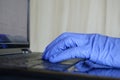 Writing hands on a computer using gloves in work