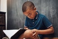 Writing helps to cultivate emotional growth. a young boy writing in a book while sitting at home.