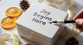 Writing inspirational message Joy Begins Here on white ceramic gift box surface created with AI Royalty Free Stock Photo