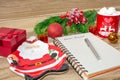 Writing a letter to Santa Claus on a wooden background with Christmas gifts, a plate in the shape of Santa Claus, a mug Royalty Free Stock Photo