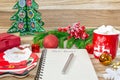 Writing a letter to Santa Claus on a wooden background with Christmas gifts, a plate in the shape of Santa Claus, a mug Royalty Free Stock Photo