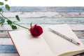 Writing for love: red rose, journal and pen. Royalty Free Stock Photo