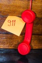 Writing 911 on memo post reminder.  sticky paper with text 911 and landline phone Royalty Free Stock Photo