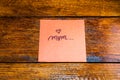 Writing mom on memo post reminder. Text on sticky paper. Mother`s day concept