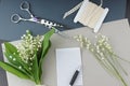 Writing a note with a declaration of love: a piece of paper with a pen lie on the table next to a bouquet of lilies of the valley Royalty Free Stock Photo