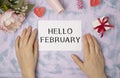 writing a note on a paper. Handwritten text HELLO FEBRUARY, motivation concept Royalty Free Stock Photo