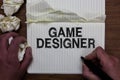 Writing note showing Game Designer. Business photo showcasing Campaigner Pixel Scripting Programmers Consoles 3D Graphics Man hold