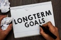 Writing note showing Longterm Goals. Business photo showcasing Strategic target that is required more time for completion Man hold