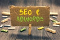 Writing note showing Seo and Adwords. Business photo showcasing Pay per click Digital marketing Google Adsense Clothespin holding