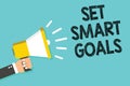 Writing note showing Set Smart Goals. Business photo showcasing Establish achievable objectives Make good business plans Man holdi