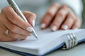 Writing in notebook, elegant pen, manicured nails, focus on hands, personal reflection, organized notes Royalty Free Stock Photo