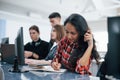 Writing in the notepad. Group of young people in casual clothes working in the modern office Royalty Free Stock Photo