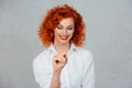 Writing. Portrait close up of happy beautiful young red head woman writing holding pen thinking looking at pencil isolated gray Royalty Free Stock Photo