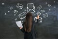 Writing and sending e-mail concept with woman drawing white envelopes on blackboard