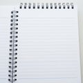 Open Spiral Bound Notebook with Lined White Pages and Metal Coils on a White Surface Royalty Free Stock Photo