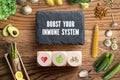 Writing slate with message BOOST YOUR IMMUNE SYSTEM surrounded by vegetables