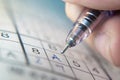 Writing on Sudoku puzzle with ballpoint pen Royalty Free Stock Photo