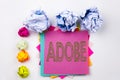 Writing text showing ADOBE written on sticky note in office with paper balls. Business concept for Software Company Name on