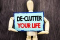 Writing text showing De-Clutter Your Life. Concept meaning Free Less Chaos Fresh Clean Routine written on Sticky Note Holding By Royalty Free Stock Photo