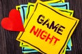 Writing text showing Game Night. Concept meaning Entertainment Fun Play Time Event For Gaming written on Stikcy Note Paper on the Royalty Free Stock Photo
