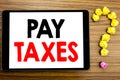 Writing text showing Pay Taxes. Business concept for Taxation Overtax Return written on tablet computer on the wooden background w