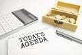 Writing text showing today's agenda . Calculator,pen,plan,glasses and black folder on grey background Royalty Free Stock Photo