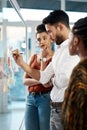 Writing things down helps us see clearer. a diverse group of businesspeople standing and using a glass board with post Royalty Free Stock Photo