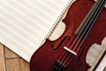 Writing Violin Music. Close up view of beautiful brown violin lying on sheets for music notes. Musical instruments.