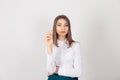 Writing. Young woman with elegant white shirt, holding ballpoint pen, looking to you camera, isolated white background, studio Royalty Free Stock Photo