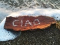 Written CIAO is a wood bark on the beach