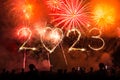 2023 new year text made with fireworks sparklers and bengal lights on night sky at midnight. Crowd of People celebrate, concert st