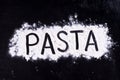 On written flour pasta. Dark background. Royalty Free Stock Photo