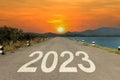 2023 written on highway road  in the middle of empty asphalt road and beautiful sunset sky. New year 20223 Royalty Free Stock Photo