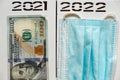 2021 and 2022 written in pen over a column in two separate columns, dollars and a medical mask, subtotal Royalty Free Stock Photo