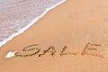 Written sale drawn on the sand Royalty Free Stock Photo