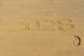 2028 written in the sand on the beach - Happy New Year and a footprint