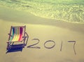 2017 written in sand write on tropical beach.