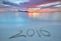 2016 written on sandy beach during sunset.