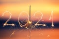 2021 written with Sparkle firework on sunset background, happy new year 2021 concept Royalty Free Stock Photo